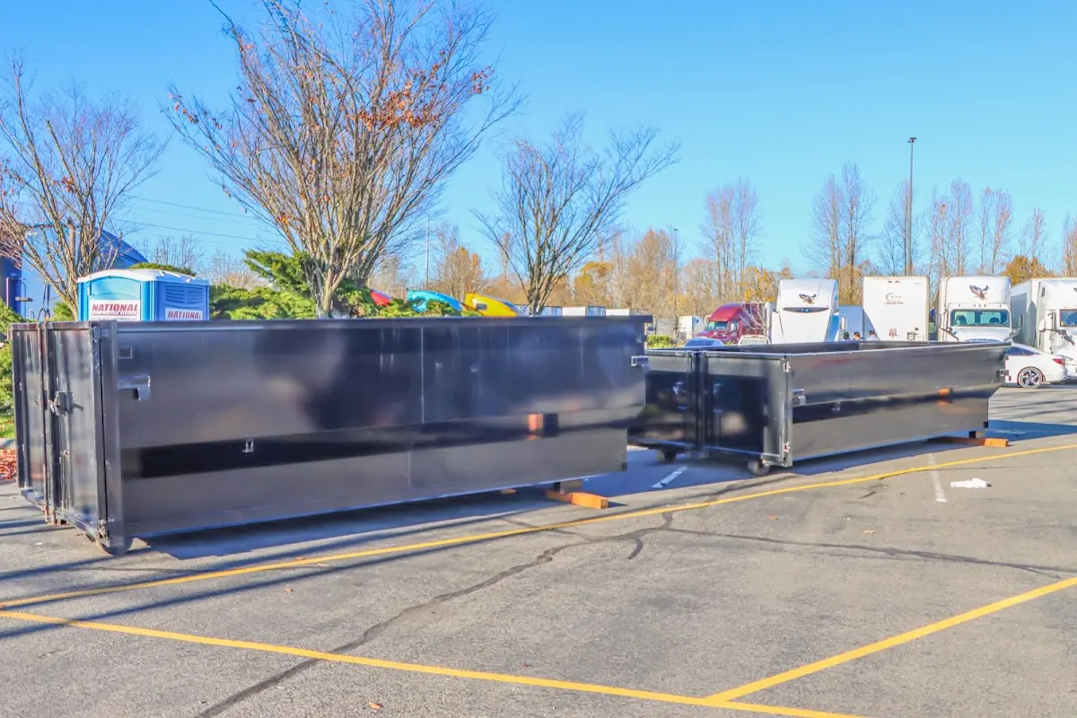 Professional dumpster rental service with roll-off container on residential driveway in Newport